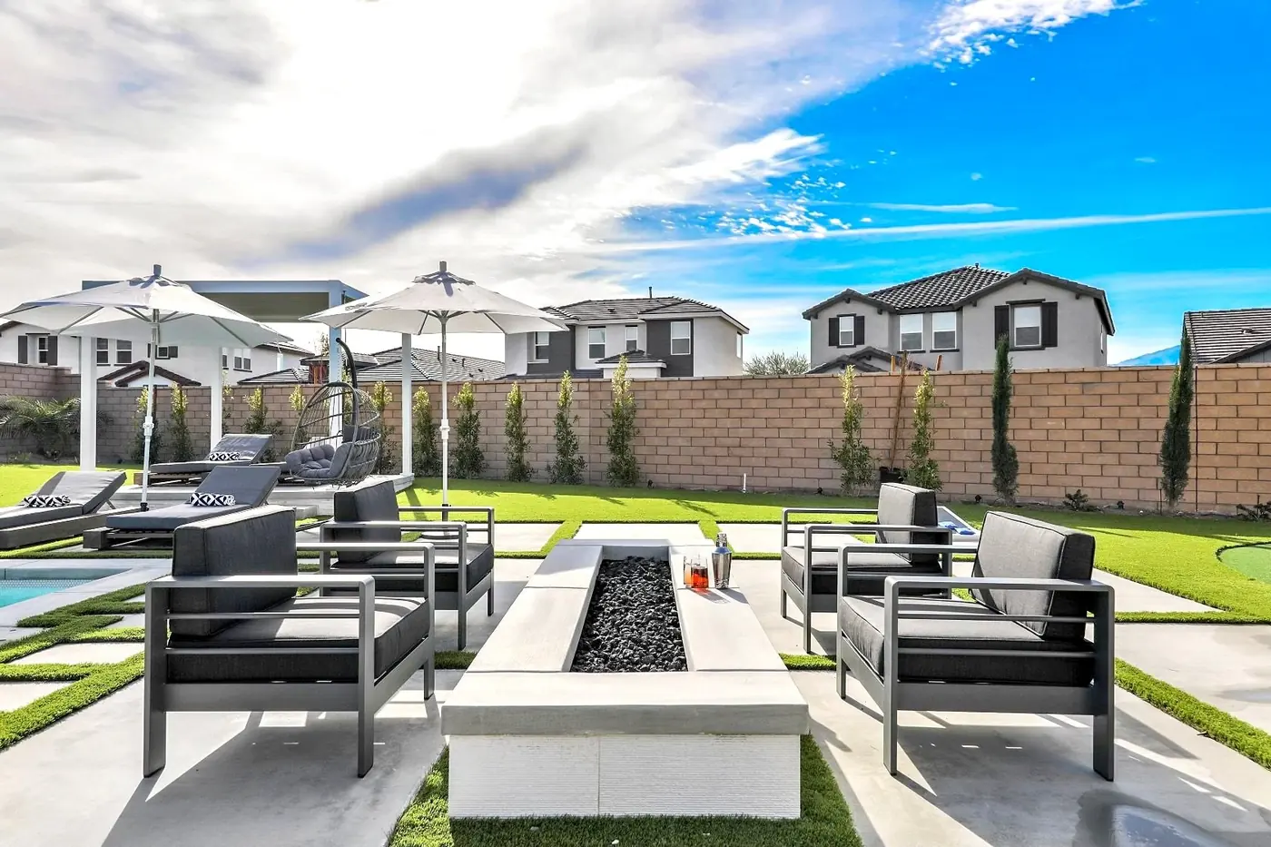 Fire table and loungers under umbrellas by day