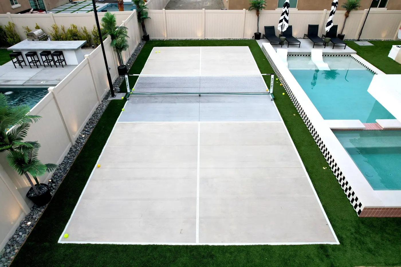 Sport court beside a pool in a backyard