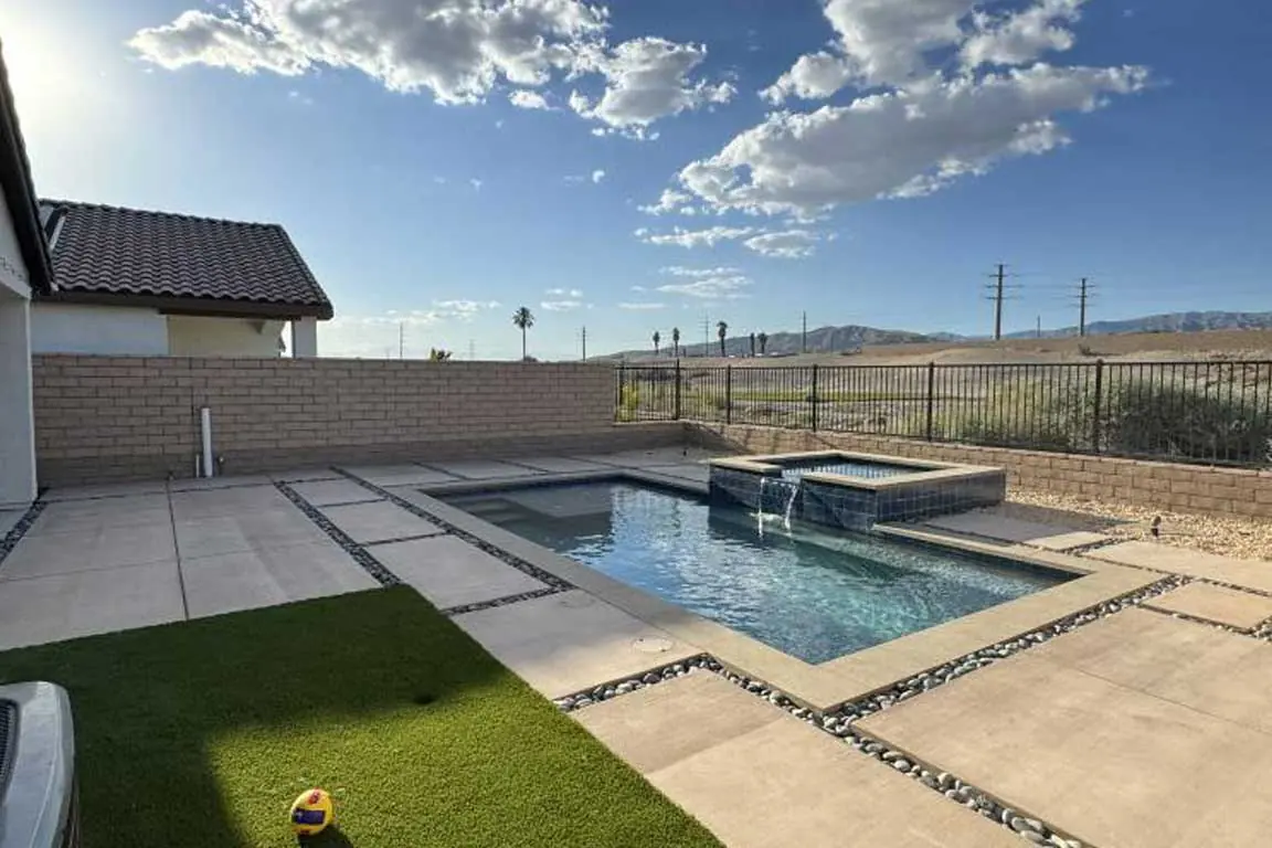 Pool and spa with mountain views and desert landscaping